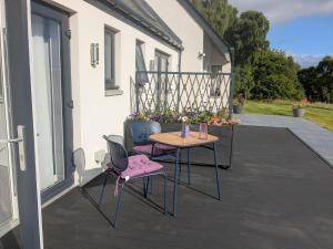 a patio with a table and chairs on a balcony at An Airigh Bed & Breakfast in Kirkhill +3 photos