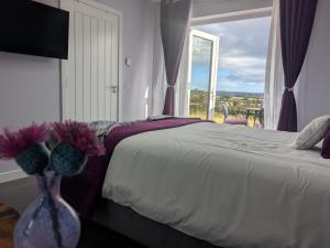 a bedroom with a bed and a vase with flowers in it at An Airigh Bed & Breakfast in Kirkhill