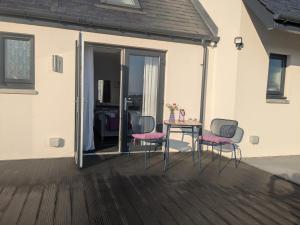 a patio with a table and chairs on a deck at An Airigh Bed & Breakfast in Kirkhill