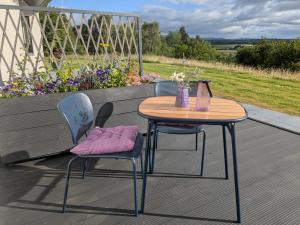 a table and chairs on a patio with flowers at An Airigh Bed & Breakfast in Kirkhill