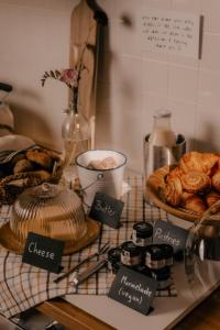 a table with bread and pastries and other food items at Oak House Vienna - Boutique Guesthouse near Meidling Station in Vienna