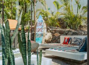 a couch sitting on a patio with plants at Outsite Todos Santos - Formerly Perro Surfero Hotel Boutique in Todos Santos +34 photos