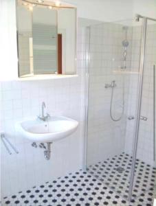 a white bathroom with a sink and a shower at Lüsser Landsitz in Bad Belzig +11 photos