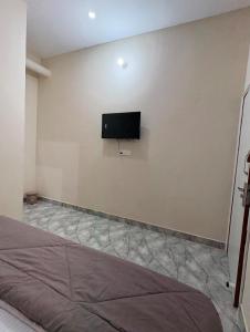 a bedroom with a flat screen tv on a wall at aadi shakti palace in Faizābād