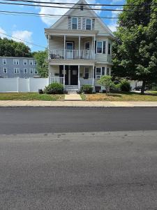 a white house with a porch and a white fence at Sleeps 6 Near Boston, Providence & Gillette in Attleboro