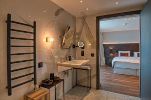 a bathroom with a sink and a bedroom at Hotel Vinifera Wine & Spa 5 Stars Superior in Balatonfüred +115 photos
