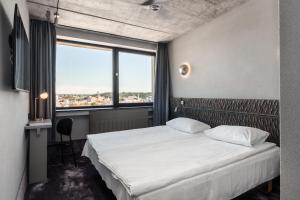 a bedroom with a bed and a large window at Hotel Panorama in Vilnius +93 photos