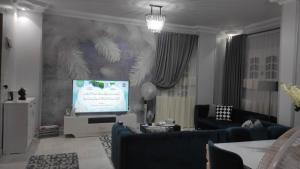 a living room with a flat screen tv and a living room with a couch at Heaven 2 in Mīt Abū Shaykhah
