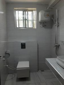 a white bathroom with a shower and a sink at Capri Hills 9 in Mwanza