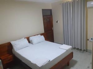 a bedroom with a bed with two white pillows at Capri Hills 9 in Mwanza