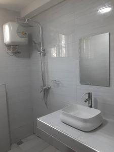 a white bathroom with a sink and a shower at Capri Hills 9 in Mwanza