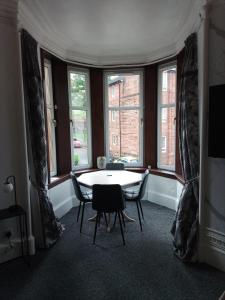 a dining room with a table and chairs and windows at Beautiful 2 double bedrooms, 2 baths apartment in Port Glasgow