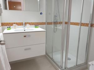 a white bathroom with a sink and a shower at Hotel Boutique Las Arenas in Es Cana