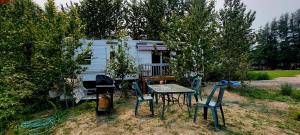 a table and chairs in front of a caravan at Le Refuge du Navigateur in Tadoussac