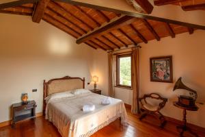 a bedroom with a bed and a window and a chair at Villa Missiano Unità Cassiopea con Piscina in Panicale