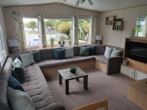 a living room with a couch and a table at Maggie's Garden Retreat in Millom