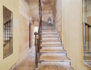 a staircase in a house with a stone wall at B&B Le Miroir aux Fées Bordeaux in Bordeaux