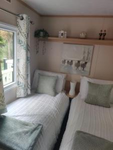 a bedroom with two beds and a window at Maggie's Garden Retreat in Millom