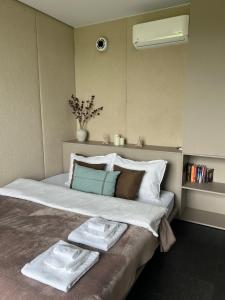a bedroom with a large bed with towels on it at Neboskhyl House in Khorosno