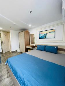 a bedroom with a large bed with blue pillows at Sencoco Hotel in Hà Quảng (4) +1 photo
