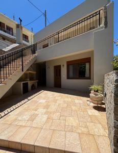a house with a staircase and a patio at Psichro Apartments Zeus in Magoulás +7 photos