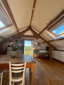 a dining room with a wooden table and windows at The Old Stable Block - Flat 2 in Wadebridge
