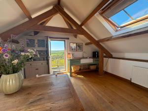 a living room with a vase of flowers on a table at The Old Stable Block - Flat 2 in Wadebridge
