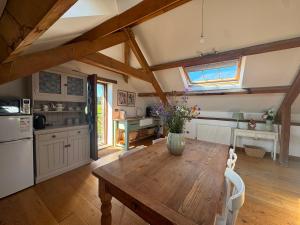 a kitchen with a wooden table with a vase on it at The Old Stable Block - Flat 2 in Wadebridge +3 photos