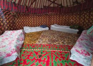 a bed in a room with two pillows on it at Этно House in Tong
