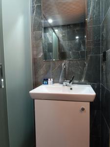 a bathroom with a sink and a mirror at Pamukkale Cleopatra in Pamukkale