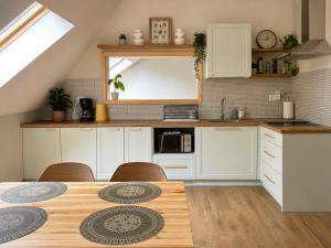 a kitchen with white cabinets and a table with chairs at Młyn Bosaka in Ojców