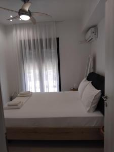 a bedroom with a large white bed with a window at Central House 2 in Ancient Epidauros
