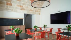 a dining room with tables and red chairs at Benedamò Home Inside in Polignano a Mare