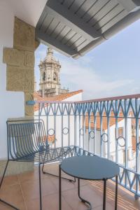 ein Balkon mit einer Bank und einem Uhrturm in der Unterkunft Hotel San Nikolas Sea Views in Hondarribia