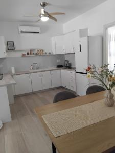 a kitchen with white cabinets and a table with chairs at Central House 2 in Ancient Epidauros