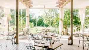 a restaurant with tables and chairs and a large window at Chateau Mcely in Mcely