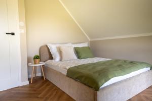 a bedroom with a bed with a green blanket at Osada Wiśniewo in Płótowa