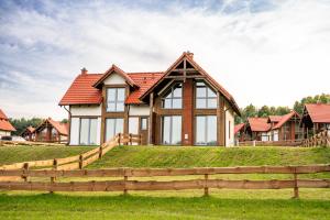 a house on a hill with a fence at Osada Wiśniewo in Płótowa