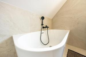 a white tub in a bathroom with a shower at Osada Wiśniewo in Płótowa
