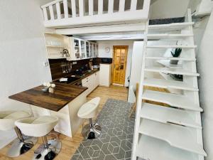 a kitchen with a loft bed and a table and chairs at Apartmány pod zvonicí, Vimperk in Vimperk