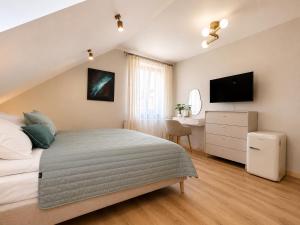 a bedroom with a bed and a desk and a television at Młyn Bosaka in Ojców