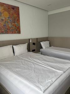 a bedroom with two beds and a painting on the wall at Sliv in Vinica
