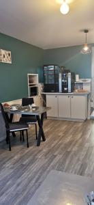 a living room with a table and a kitchen at Aux Chambres du Mont in Huisnes-sur-Mer