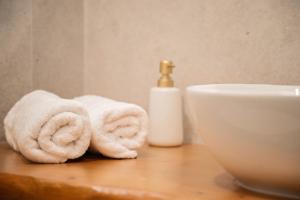 a bathroom with towels on a table next to a sink at Elysian suite in Parga +11 photos