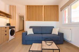 a living room with a blue couch and a table at Elysian suite in Parga