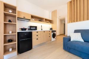 a living room with a blue couch and a kitchen at Elysian suite in Parga