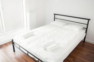a bed with white sheets and pillows in a room at Apartament Verde in Łódź