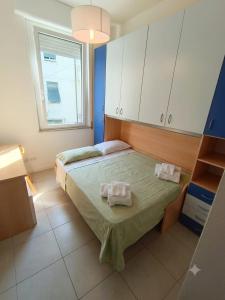 a bedroom with a bed with two towels on it at Free Parking a 100 mt dal mare-Wave HuoSe in Pesaro