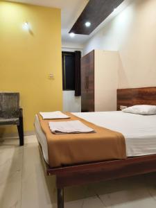 a bedroom with a large bed and a chair at Rutam villa in Shendi
