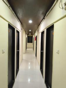 a hallway of an office building with black doors at Rutam villa in Shendi